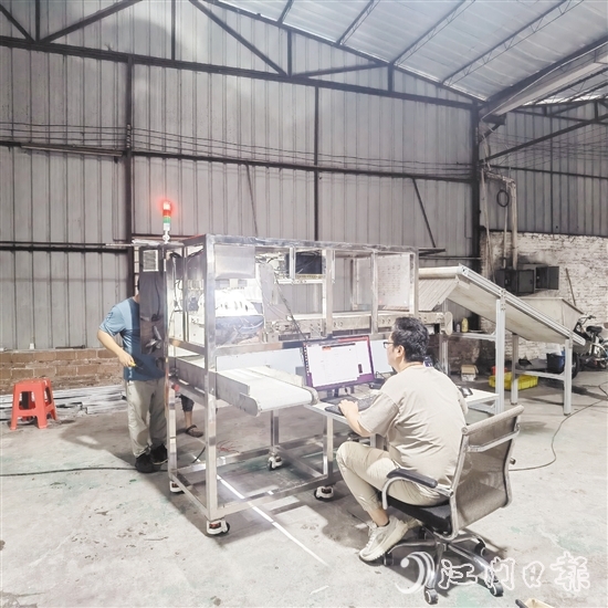 鷹視光電工作人員正在對AI視覺檢測設(shè)備進(jìn)行調(diào)試。