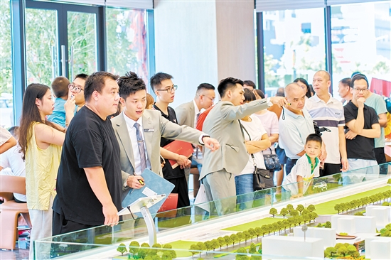 在駿景灣·品悅，銷售人員忙著為客戶介紹樓盤情況。