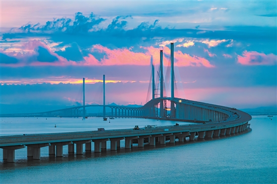 此起彼伏的“海上長(zhǎng)龍”與落日相映成輝。