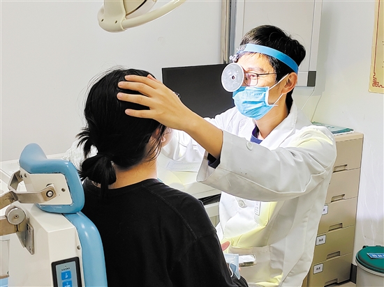 醫(yī)生為患者檢查鼻子。