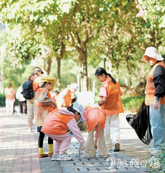 江門市范羅岡小學家長志愿服務(wù)隊通過“大手拉小手”的形式，在范羅岡小學濱江校區(qū)周邊開展全方位清潔巡查。