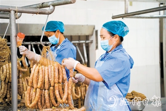 工人們正在制作禮樂(lè)臘味。邱昱