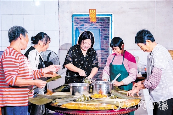 非遺傳承人呂艷卿正在傳授柴火粽的制作技藝。