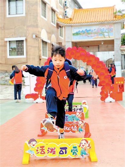 蓬江區(qū)荷塘鎮(zhèn)聯(lián)育小學(xué)學(xué)生跨過吉祥欄。