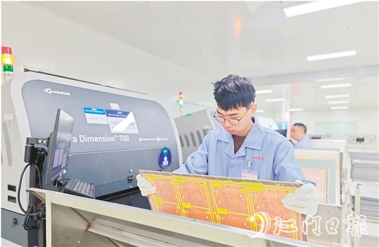 在鶴山中富生產(chǎn)車間，員工操作自動化設備趕制電路板。
