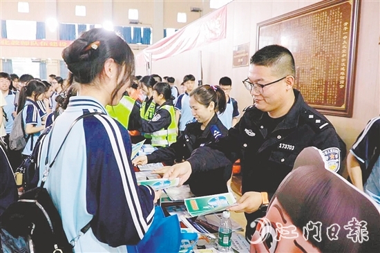 民警向?qū)W生發(fā)放安全知識宣傳資料。