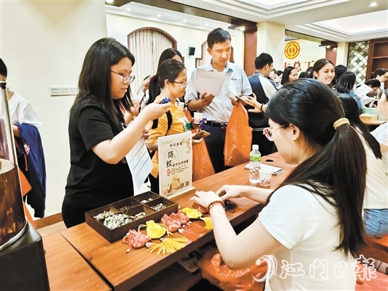 職工們與醫(yī)生探討中藥的成分和比例，制作防感驅(qū)蚊中藥香囊。