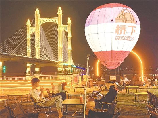 夜幕降臨，潭江兩岸燈火闌珊，市民、游客在“橋下咖啡營(yíng)地”品咖啡、賞夜景，享受愜意時(shí)光。