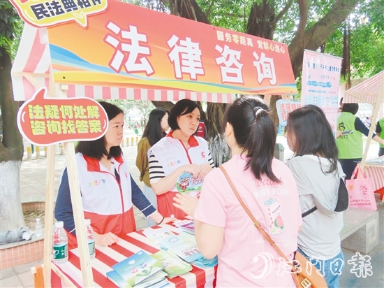 在法律援助攤位，司法系統(tǒng)黨員志愿者耐心解答群眾的法律咨詢。