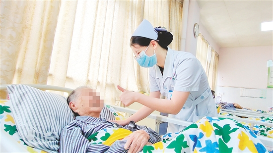 這是一雙傳遞溫度的手?！坝袝r(shí)去治愈，常常去幫助，總是去安慰”，江門市第三人民醫(yī)院內(nèi)科護(hù)士容海清站在床邊，將大拇指高高豎起，用輕柔的話語與溫暖的肢體語言，鼓勵臥床患者樹立康復(fù)的信心。