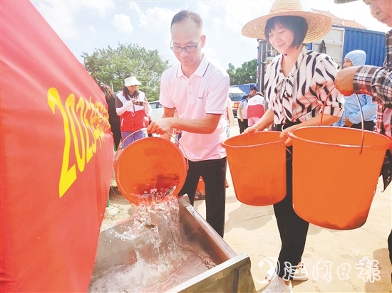 參與人員將魚(yú)苗緩緩倒入放流槽。