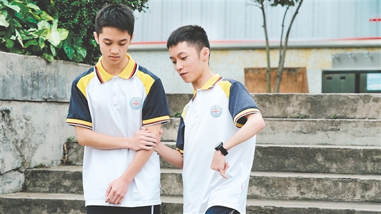 校園里，弟弟（左）和哥哥（右）相互扶持。