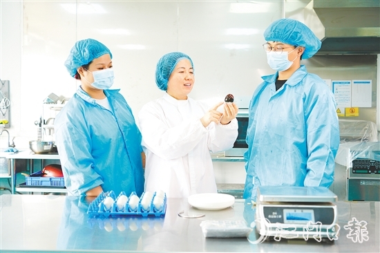 在培訓(xùn)室里，梁艷芬（中間白衣）和大家交流蛋品檢測方式。