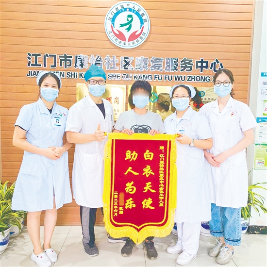 李明給康復(fù)中心醫(yī)護(hù)人員送上錦旗。