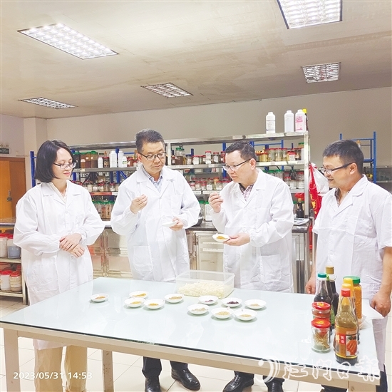 陳杰（右二）和同事仔細比對新研發(fā)產品的各項指標。