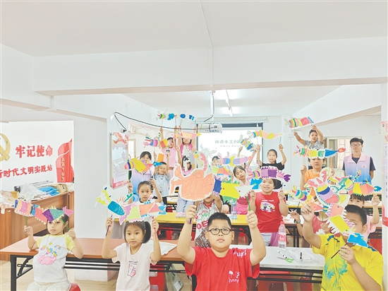 孩子們手持自制荷塘紗龍一起合照，課堂變民俗小舞臺(tái)。
