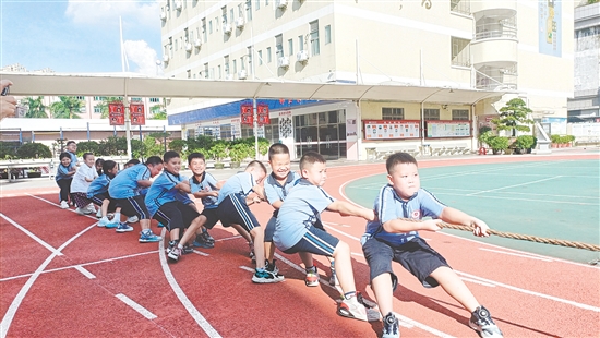 參賽隊(duì)員們緊握長(zhǎng)繩，齊心協(xié)力，鼓足勁拼命往后拉。