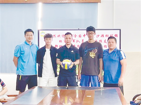 鄭銘毅（左二）與譚華鋒（右二）將親筆簽名的排球贈予母校。