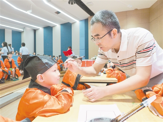 在朱砂啟智環(huán)節(jié)，教師用毛筆在新生的額頭點上紅痣。