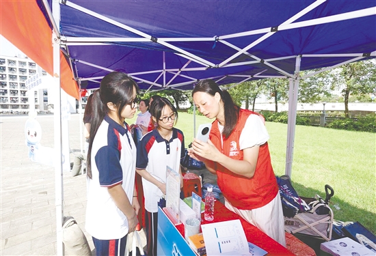 工作人員向新入學學生介紹醫(yī)保線上辦事流程。