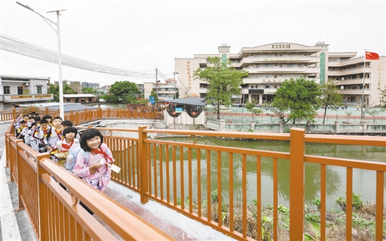 雙橋小學(xué)的學(xué)生放學(xué)后在新修建的步道上結(jié)伴而行，身旁的車流被欄桿有效隔離，構(gòu)筑起校園交通的安全防線。