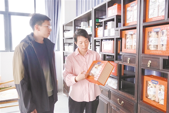 江門農(nóng)商銀行工作人員（左）走訪李樣講（廣東）陳皮有限公司。