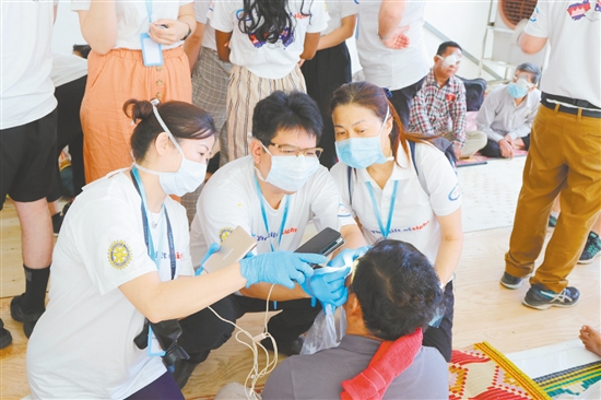 鐘景賢參加“柬埔寨光明之行”，為當?shù)匮奂不颊哌M行檢查。