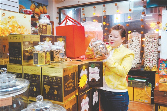 在新會(huì)傳誠(chéng)廣陳皮商鋪，負(fù)責(zé)人任霞在查看新會(huì)陳皮禮盒情況。