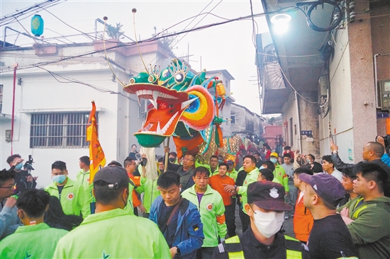 村民們高舉金龍，穿街過巷進行巡游。