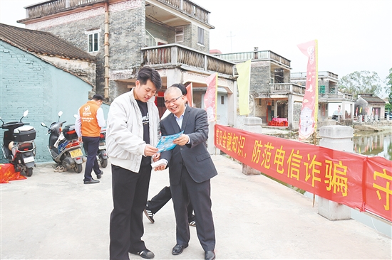 宣傳員向群眾詳細(xì)講解金融知識(shí)。