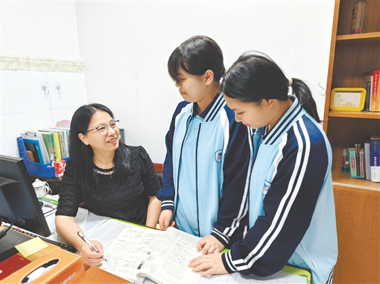 伍小勤在輔導(dǎo)學(xué)生。