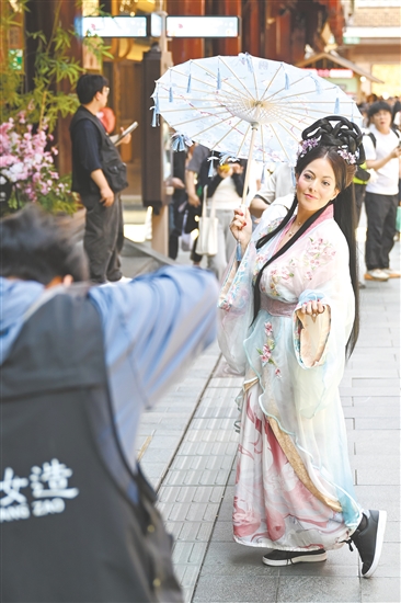 5月5日，外國游客在上海豫園商城內(nèi)體驗(yàn)古風(fēng)妝造旅拍。新華社發(fā)