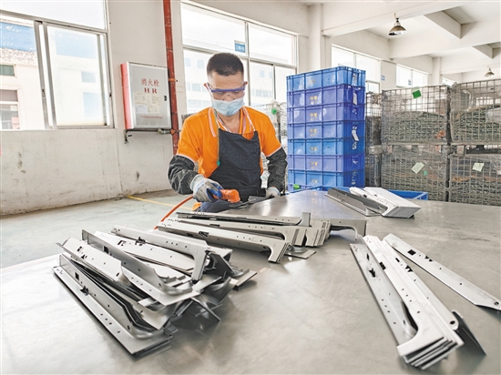 在江門市華譽制造有限公司的生產(chǎn)車間，52歲的殘疾人員工黃日道在認(rèn)真打磨零部件。
