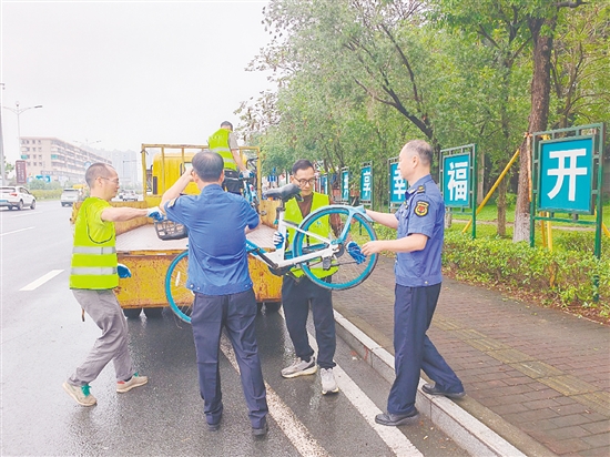 執(zhí)法人員清理違停共享單車。