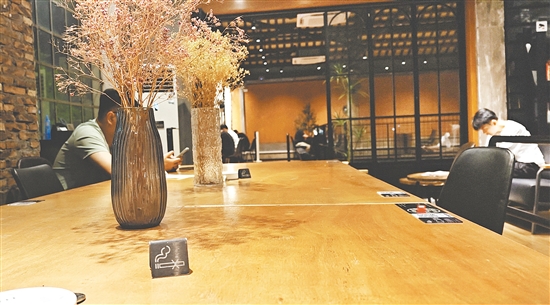 咖啡店的室內(nèi)桌子上放著禁煙標識。