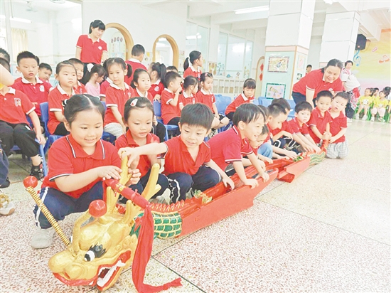 在長安幼兒園，小朋友們與龍頭、龍尾互動。