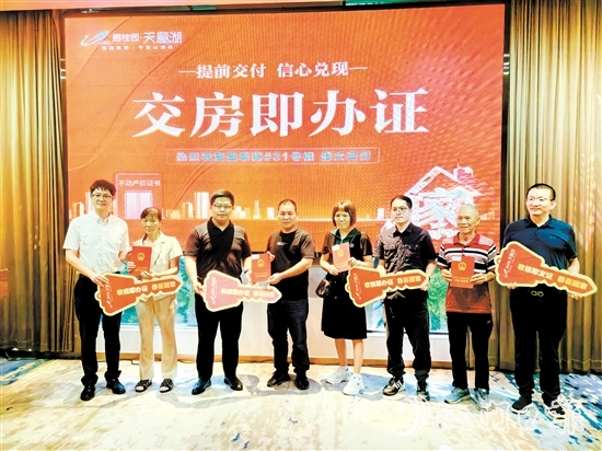 業(yè)主喜拿房產(chǎn)證和鑰匙。