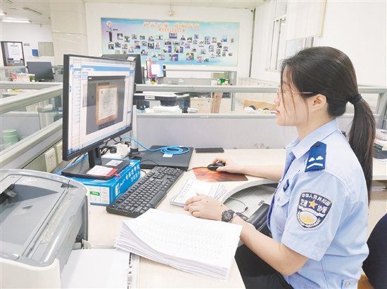 車管所網(wǎng)辦中心工作人員在對用戶提交的資料進行審核。
