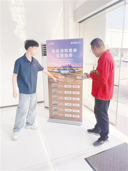 銷售人員向市民介紹優(yōu)惠政策。